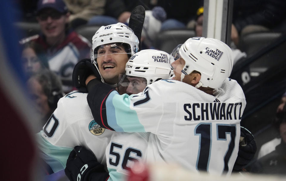 From left, Seattle Kraken center Matty Beniers is congratulated after scoring a goial by right wing Kailer Yamamoto and center Jaden Schwartz in the second period of an NHL hockey game against the Colorado Avalanche on Thursday, Nov. 9, 2023, in Denver. (AP Photo/David Zalubowski)