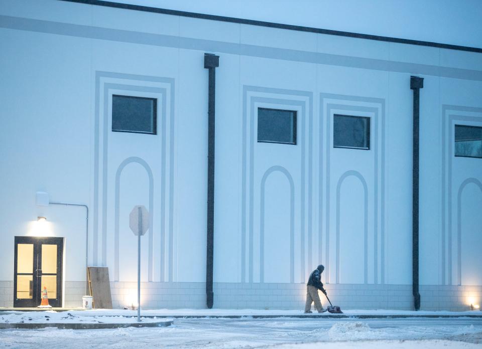 A worker clears a sidewalk at Al Huda Foundation on Thursday, Feb. 3, 2022, in Fishers after a major winter storm brought snow and ice overnight with more on the way.