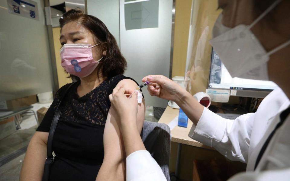 A woman wearing a face mask gets a flu shot at the Korea Association of Health Promotion in Seoul, South Korea - Newsis