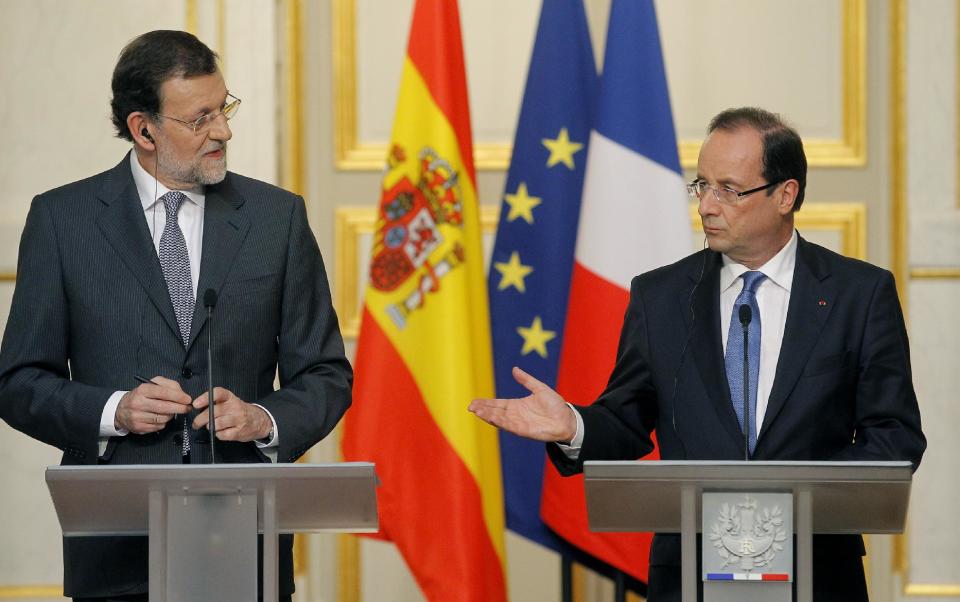 French President Francois Hollande reacts during his meeting with Spain's Prime Minister Mariano Rajoy, left, in Elysee Palace, Paris, Wednesday, May 23, 2012. (AP Photo/Jacques Brinon)