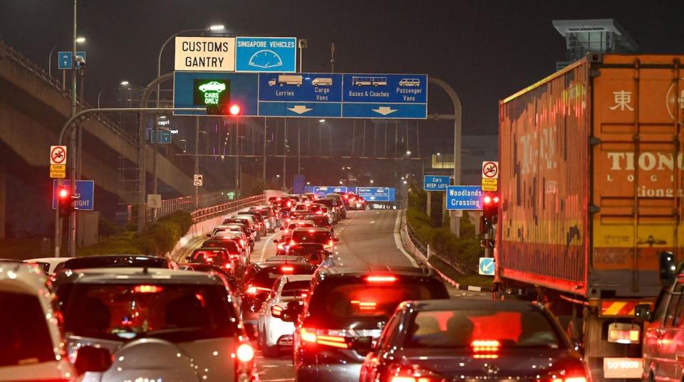 Imagen de varios vehículos atrapados en un embotellamiento en la carretera de Woodlands Checkpoint.