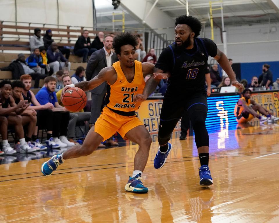 Davin Walker of Siena Heights is defended by Henry Spate of Madonna during an 82-65 loss Wednesday night.