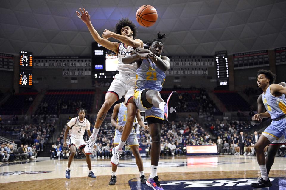 Connecticut's Andre Jackson Jr., left, and Long Island's Cheikh Ndiaye jump for a rebound during the first half of an NCAA college basketball game, Saturday, Dec. 10, 2022, in Storrs, Conn. (AP Photo/Jessica Hill)