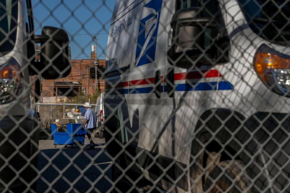 A postal service worker moves mail at a Kansas City area post office.