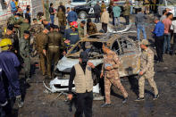 Iraqi security forces inspect the site of an explosion in Basra, Iraq, Tuesday, Dec. 7, 2021. The explosion rocked the center of Iraq’s southern city of Basra, killing at least four people and wounding several others. Local news reports initially reported a car bomb, but the governor of Basra told reporters on the scene that a motorcycle had exploded. (AP Photo/Nabil al-Jurani)