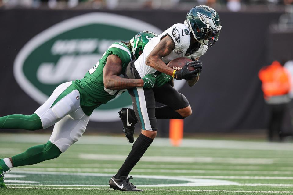 Oct 15, 2023; East Rutherford, New Jersey, USA; Philadelphia Eagles wide receiver <a class="link " href="https://sports.yahoo.com/nfl/players/33398" data-i13n="sec:content-canvas;subsec:anchor_text;elm:context_link" data-ylk="slk:DeVonta Smith;sec:content-canvas;subsec:anchor_text;elm:context_link;itc:0">DeVonta Smith</a> (6) fights for yards as New York Jets linebacker Quincy Williams (56) tackles during the first half at MetLife Stadium. Mandatory Credit: Vincent Carchietta-USA TODAY Sports