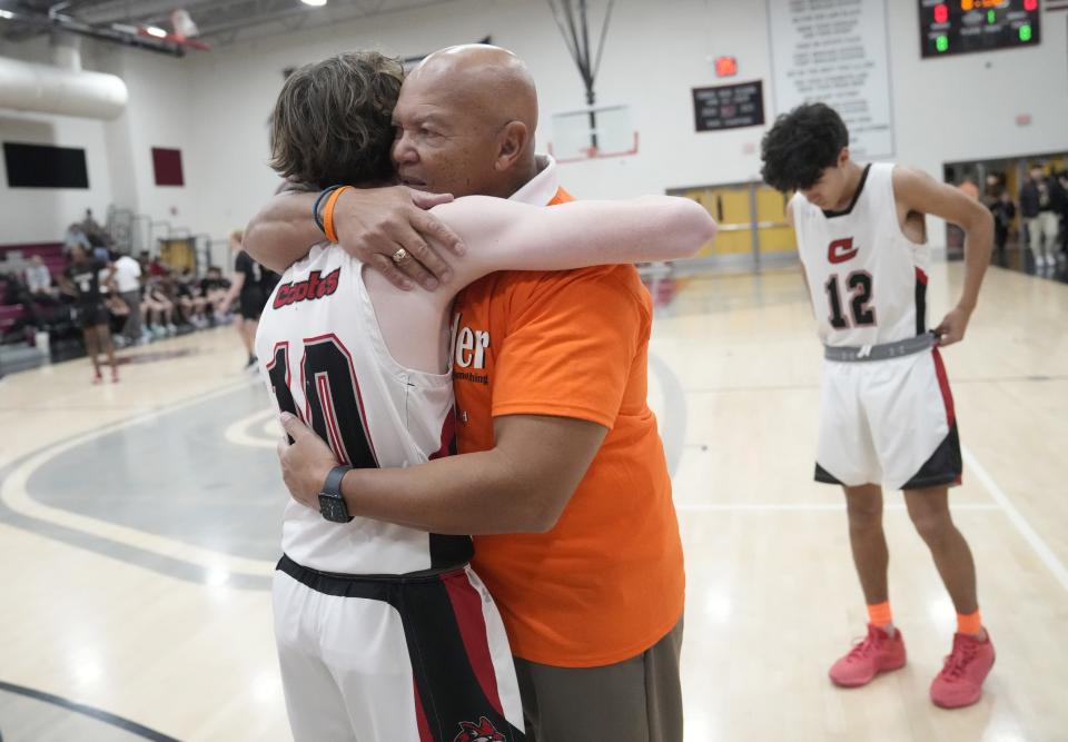 Combs High School basketball player Logan Tuckfield hugs head coach Hosea Graham before a Teen Violence Awareness game in San Tan Valley, Ariz., on Jan. 23, 2024, against Eastmark after the brutal October beating death of Combs basketball player Preston Lord.