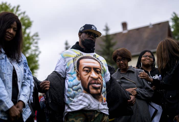 Terrence Floyd (C) removes his jacket to show a shirt bearing the face of his brother, George Floyd, during a vigil on May 25, 2022, in Minneapolis, Minnesota.