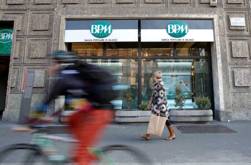 A woman walks in front of the Banca Popolare di Milano (BPM) bank in downtown Milan