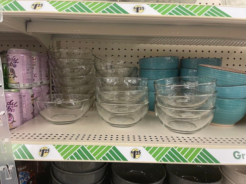 Glass bowls on shelf above $1.25 sign.