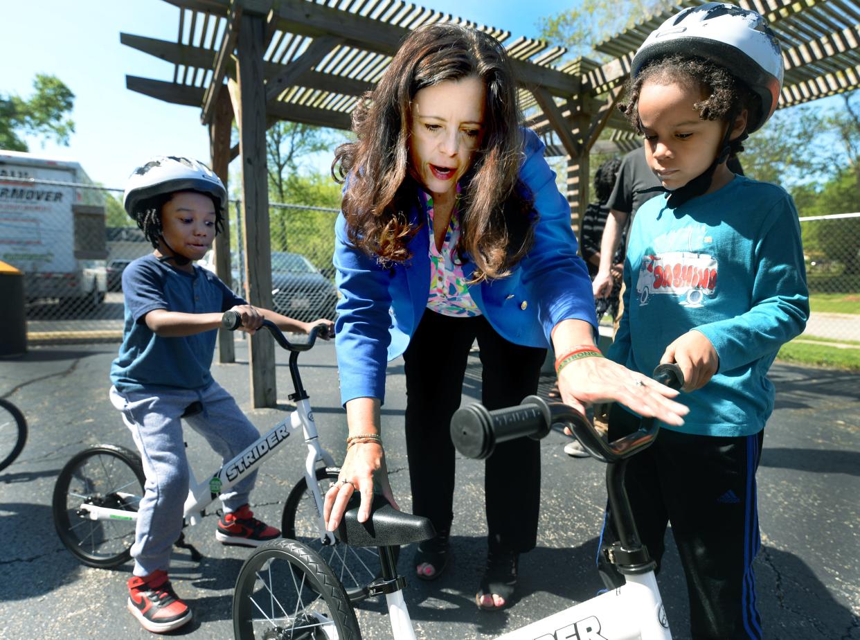 Springfield Mayor Misty Buscher helps Harvard Park Elementary kindergartner Christian Wright, 6, right, with one of the bikes donated to the school by HDR, Inc., an engineering and design company, on April 30, 2024.