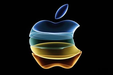 The Apple logo is displayed at an event at their headquarters in Cupertino