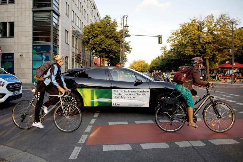 A car owned by ride-hailing company Uber drives in the city's Mitte neighborhood. The European Parliament on 24 April approved a forthcoming law on when workers on platforms like Uber and Deliveroo should be treated as employees.Platforms have argued that such workers are self-employed, excluding them from some European Union labour rights such as paid holidays and sick leave. Carsten Koall/dpa