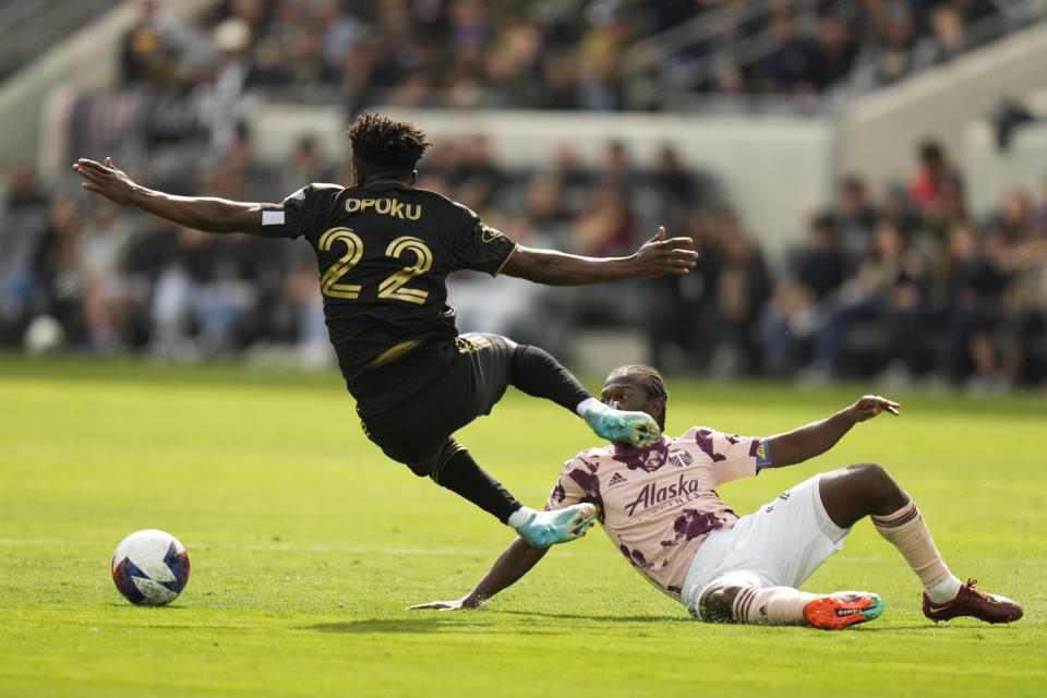 Los Angeles FC forward Kwadwo Opoku (22) is tackled by Portland Timbers midfielder Diego Chara (21) during the first half of an MLS soccer match Saturday, March 4, 2023, in Los Angeles. (AP Photo/Jae C. Hong)