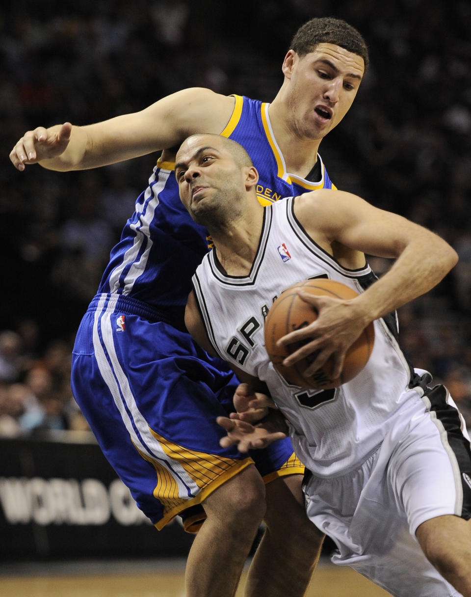 San Antonio Spurs guard Tony Parker, right, of France, drives around Golden State Warriors guard Klay Thompson during the first half of an NBA basketball game on Wednesday, April 2, 2014, in San Antonio. (AP Photo/Darren Abate)