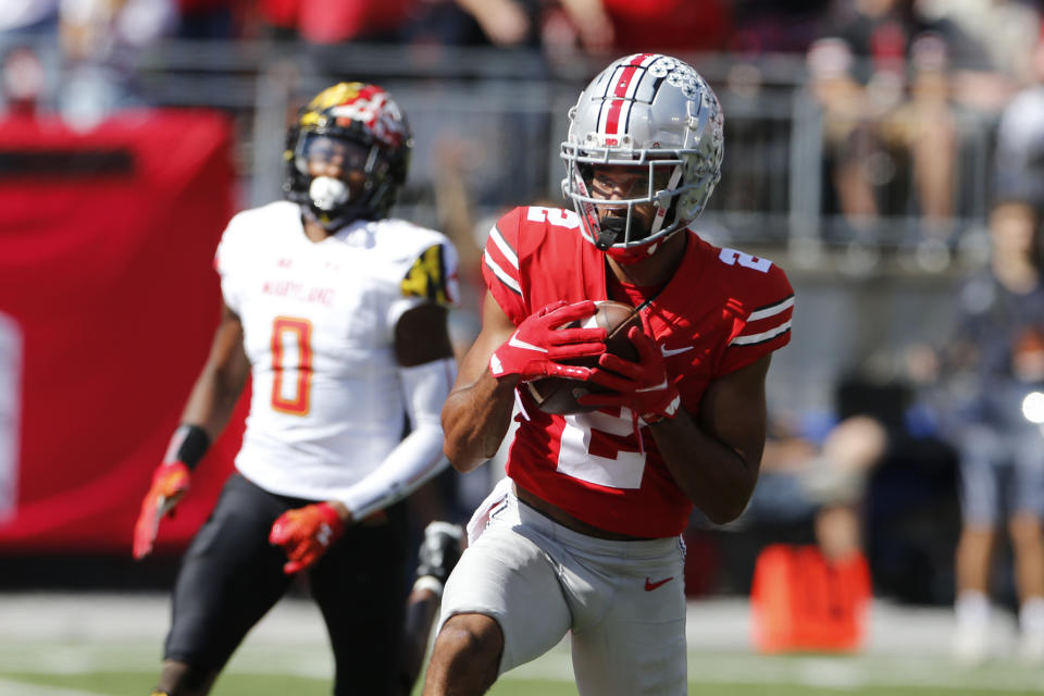 Ohio State receiver Chris Olave, right, catches a touchdown pass in front of Maryland linebacker Terrence Lewis during the first half of an NCAA college football game Saturday, Oct. 9, 2021, in Columbus, Ohio. (AP Photo/Jay LaPrete)