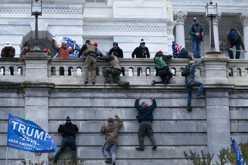 Donald Trump supporters scaling the west wall of the U.S. Capitol building in Washington on Jan. 6, 2021. (AP Photo/Jose Luis Magana)