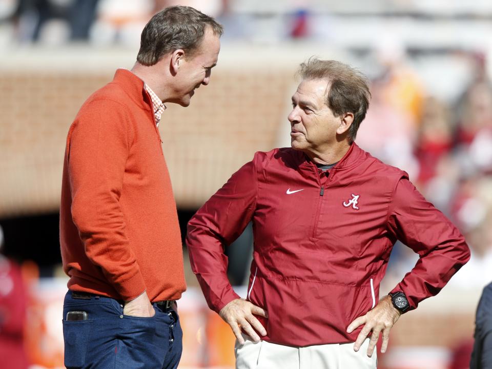 Alabama head coach Nick Saban talks with former Tennessee quarterback Peyton Manning before an NCAA college football game, Saturday, Oct. 20, 2018, in Knoxville, Tenn. (AP Photo/Wade Payne)