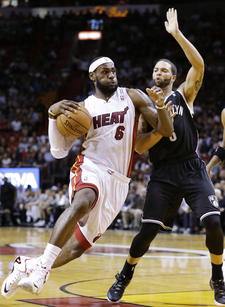 Miami Heat forward LeBron James (6) goes up for a shot against Brooklyn Nets guard Deron Williams during the first half of an NBA basketball game, Wednesday, March 12, 2014, in Miami. (AP Photo/Wilfredo Lee)