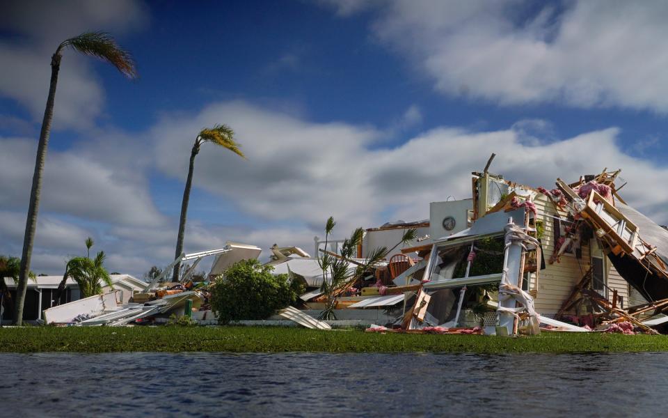 A collapsed building stands near a flooded river in the aftermath of Hurricane Ian in Punta Gorda on Sept. 29, 2022.