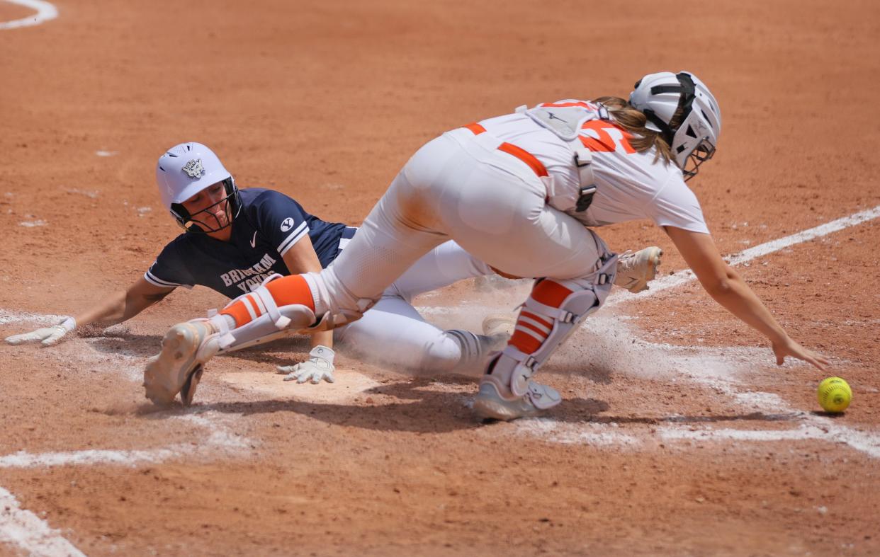 BYU outfielder Taryn Lennon (15) slides home to score as Oklahoma State catcher Caroline Wang (66) reches for the ball in the sixth inning of a Big 12 softball game between the Oklahoma State Cowgirls (OSU) and BYU at Devon Park in Oklahoma City, Thursday, May 9, 2024. BYU won 7-2.