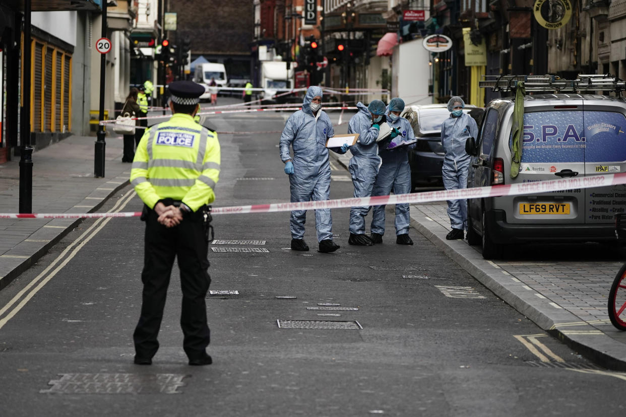 Forensics officers and police at the scene in Shaftesbury Avenue, where two male police officers were stabbed, in London, Friday, Sept. 16, 2022. London’s police force says two officers have been hospitalized after being stabbed in central London early Friday. It says the attack is not being treated as terrorism. The Metropolitan Police force says officers “encountered a man with a knife” in the Leicester Square area, a busy tourist hub, at around 6 a.m. (Aaron Chow/PA via AP)