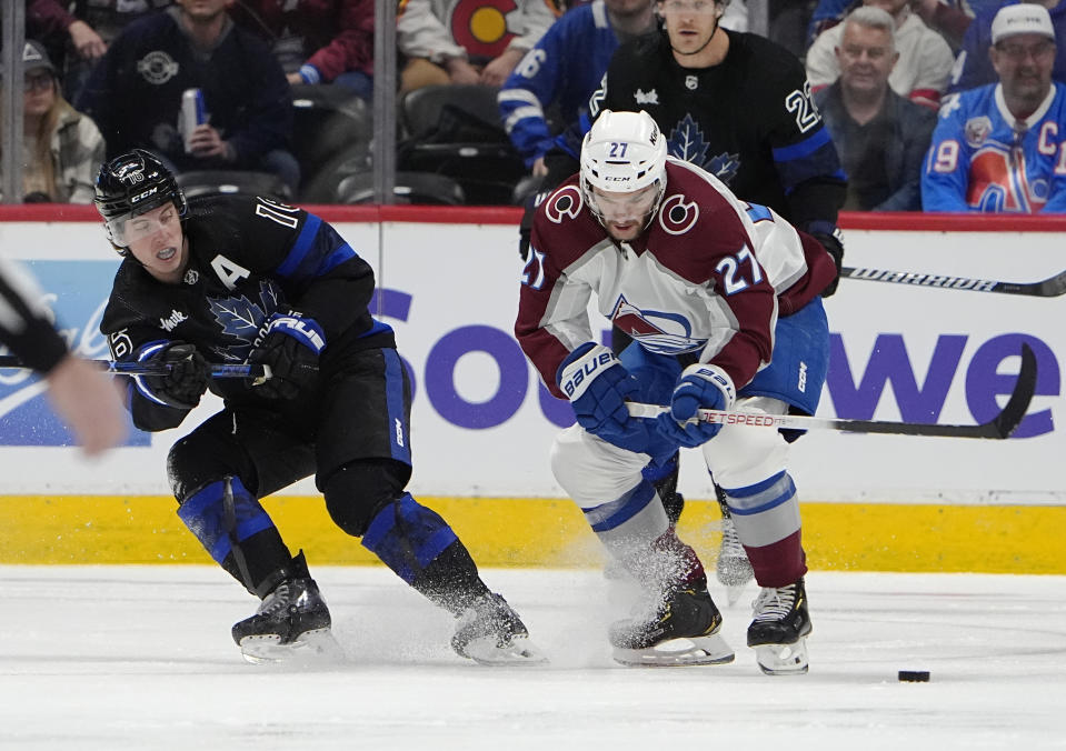 Toronto Maple Leafs right wing Mitchell Marner, left, and Colorado Avalanche left wing Jonathan Drouin pursue the puck in the second period of an NHL hockey game Saturday, Feb. 24, 2024, in Denver. (AP Photo/David Zalubowski)