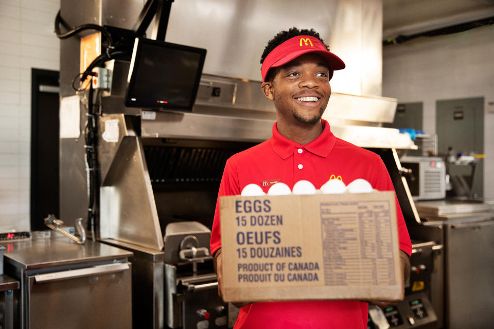 McDonald's Canada employee carrying a box of Grade A Canadian eggs