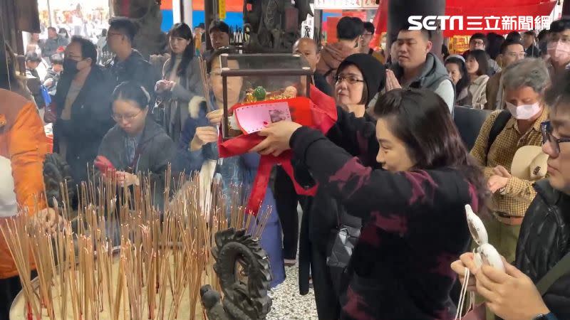 信眾將金雞母繞過香爐，祈求好運來。