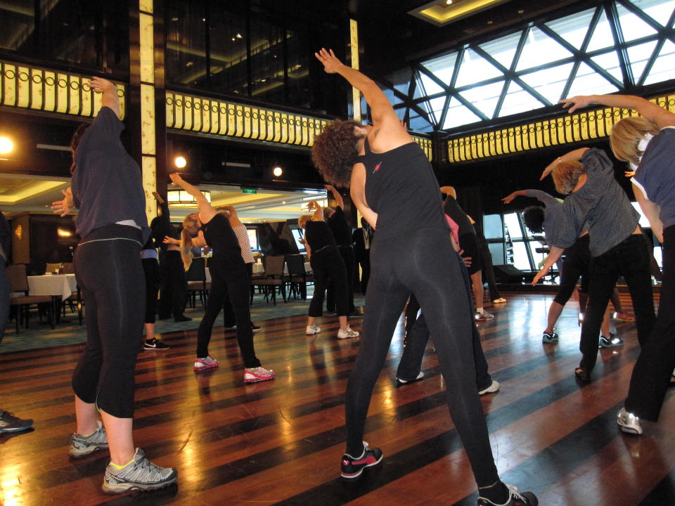 This May 9, 2013 photo shows a fitness class designed by the athletic trainer for the Rockettes, Elaine Winslow, and taught to passengers aboard the Norwegian Breakaway cruise ship. The Rockettes, famed for their kick line at the Radio City Music Spectacular, are the godmothers for the ship. (AP Photo/Beth J. Harpaz)