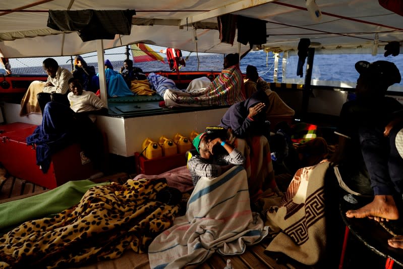 Migrants rest on board of NGO Proactiva Open Arms rescue boat in central Mediterranean Sea