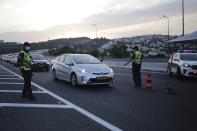 Israeli police officers check cars at a checkpoint during a three-week lockdown near Jerusalem, Sunday, Sept. 20, 2020. Israel went back into a full lockdown to try to contain a coronavirus outbreak that has steadily worsened for months. (AP Photo/Sebastian Scheiner)