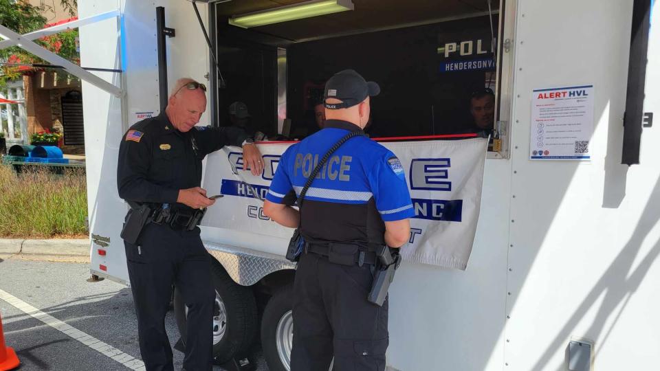 Hendersonville Police Chief Blair Myhand looks at his phone as he stands at the Hendersonville Police Department booth at the North Carolina Apple Festival on Sept. 1.