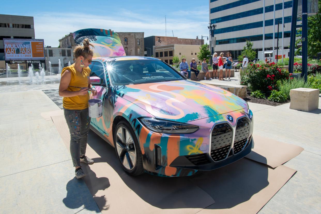 Kansas City artist Jenny Meyer-McCall creates a work of art out of a BMW i4 electric car as part of an exhibit for the Mulvane Art Fair on Thursday at Evergy Plaza.