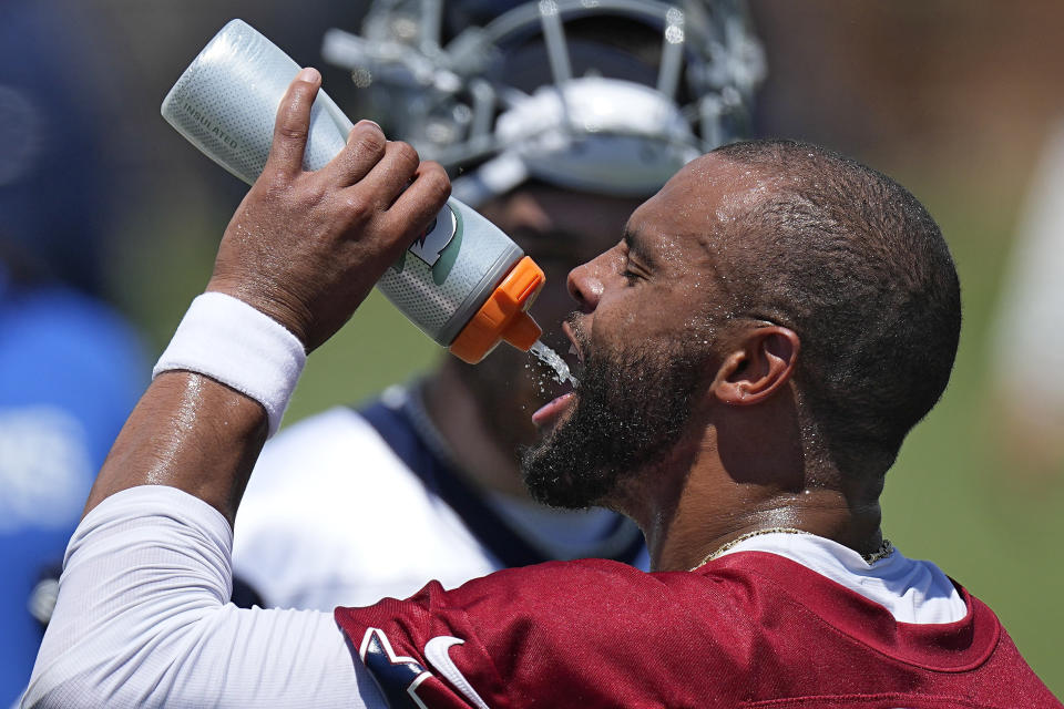 Dak Prescott, quarterback de los Cowboys de Dallas, se hidrata durante el campamento de entrenamiento del equipo, el miércoles 26 de julio de 2023, en Oxnard, California. (AP Foto/Mark J. Terrill)