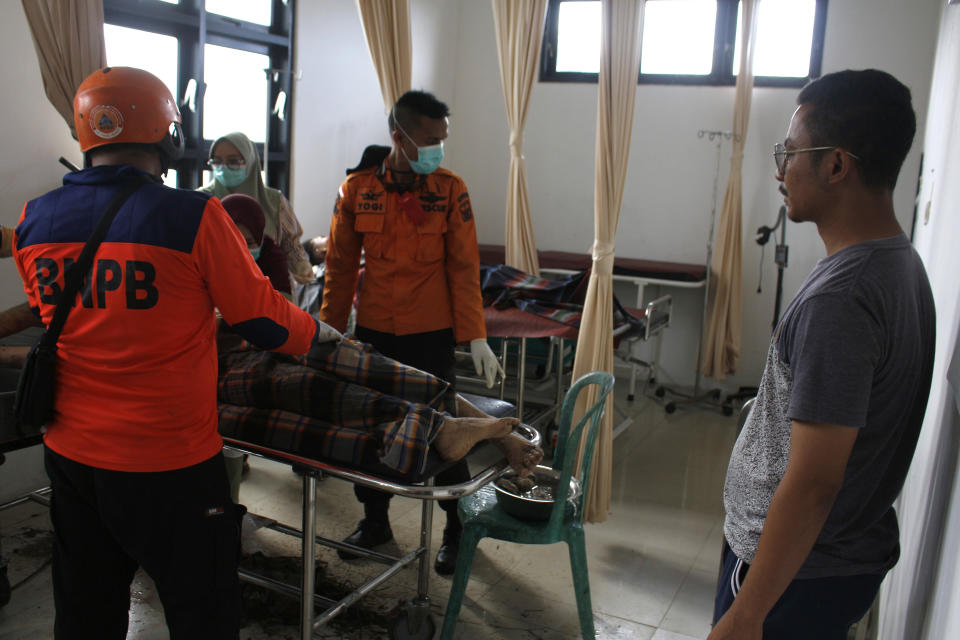 Rescuers put the body of a victim of a flash flood on a gurney at a local community health center in Padang Pariaman, West Sumatra, Indonesia, Sunday, May 12, 2024. Heavy rains and torrents of cold lava and mud rushing down a volcano on Indonesia’s Sumatra island have triggered flash floods that killed more than a dozen of people and injured several others, officials said Sunday. (AP Photo/Fachri Hamzah)