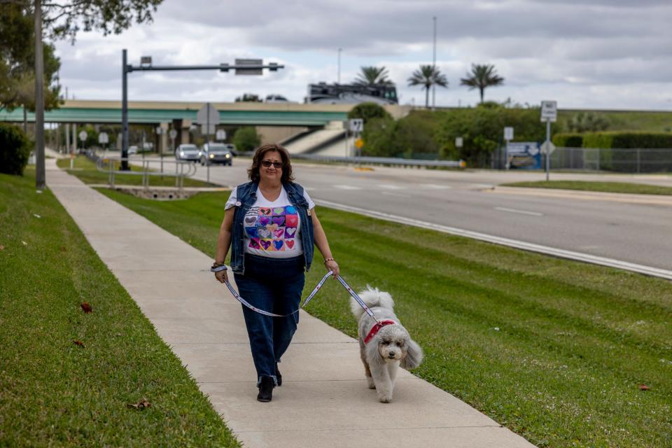 Diana Haneski, walks River, a therapy dog that she owns and cares for, outside Majory Stoneman Douglas High School on Feb. 10, 2024, in Parkland, Florida. The dog hangs out with students during the week on the campus where a mass shooting occurred six years ago.