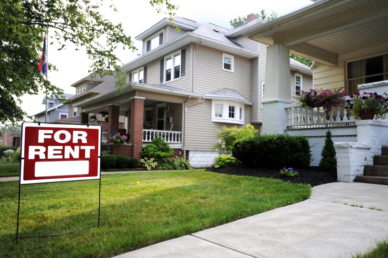 A for-rent sign in front of a suburban house in the US