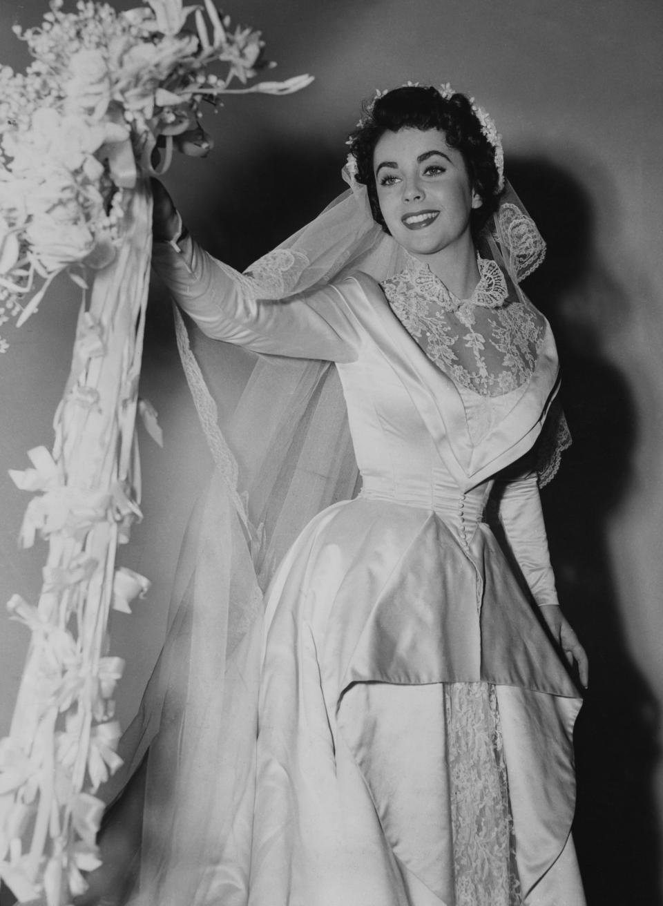 Kay wearing a huge, elaborate dress with a collar