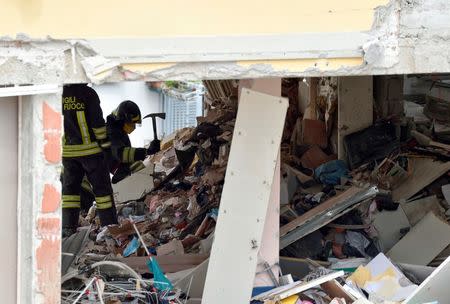 Italian firefighters work in the debris after a residential building partially collapsed on Sunday following an explosion in Milan, Italy, June 12, 2016. REUTERS/Flavio Lo Scalzo