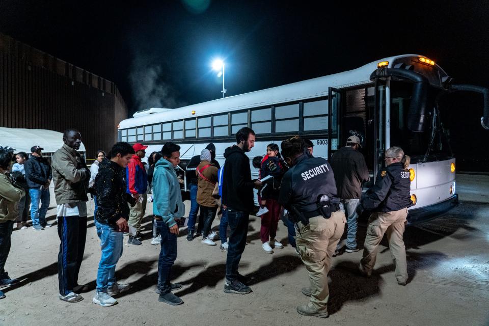 Migrants and asylum seekers are patted down by security personnel as they prepare to board a bus after being detained by U.S. Border Patrol agents after crossing the U.S.-Mexico border in Somerton, Ariz., near the Cocopah Indian Tribe's reservation boundaries, on May 11, 2023.