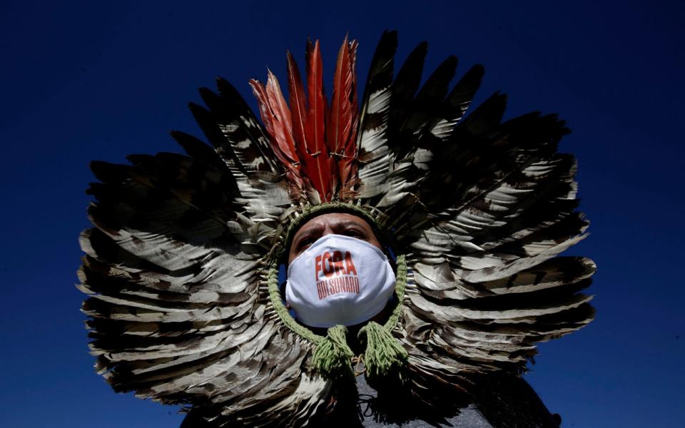 Kretan Kaingang, an indigenous leader, wears a protective face with a hashtag that reads in Portuguese: "Out Bolsonaro" during a protest demanding the president is impeached on May 2 -  Eraldo Peres/AP