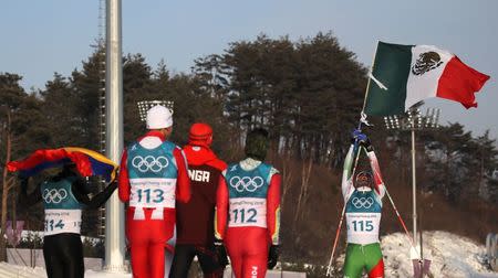 Cross-Country Skiing – Pyeongchang 2018 Winter Olympics – Men's 15km Free – Alpensia Cross-Country Skiing Centre – Pyeongchang, South Korea – February 16, 2018 - German Madrazo of Mexico holds the Mexican flag as Sebastian Uprimny of Colombia, Samir Azzimani of Morocco, Pita Taufatofua of Tonga and Kequyen Lam of Portugal look on. REUTERS/Carlos Barria