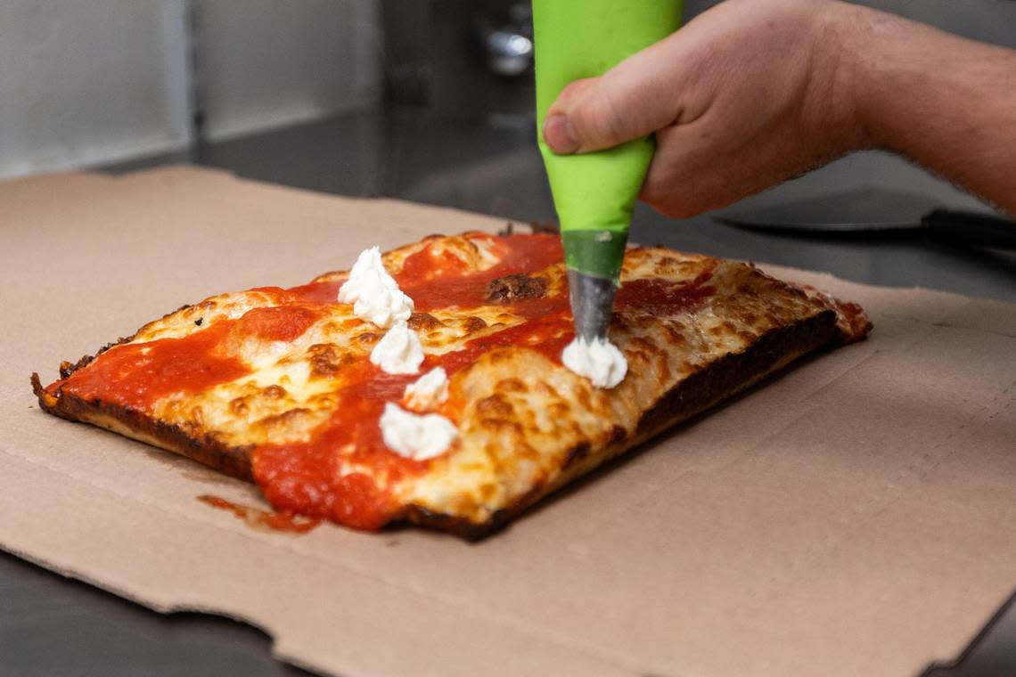 Matty Evans, chef of Rise Up Pizza, applies burrata on the top of a Detroit-style pizza from within the kitchen of the restaurant’s location within Horse & Jockey Pub on Cheapside, November 9, 2023. Marcus Dorsey/mdorsey@herald-leader.com