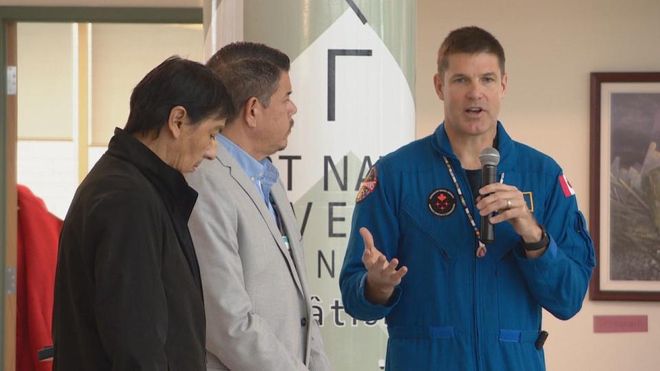 Jeremy Hansen speaking at U of R next to his friends from Turtle Lodge.  Next to him is Turtle Lodge leader Dave Courchene, and on the far left is patch artist Henry Guimond. 