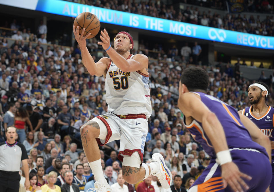 Denver Nuggets forward Aaron Gordon, left, drives the lane as Phoenix Suns guard Devin Booker defends in the first half of Game 5 of an NBA basketball Western Conference semifinal series Tuesday, May 9, 2023, in Denver. (AP Photo/David Zalubowski)