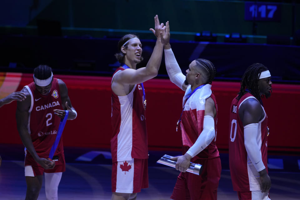 Canada forward Kelly Olynyk (13) and Canada forward Dillon Brooks (24) celebrate after the Basketball World Cup bronze medal game between the United States and Canada in Manila, Philippines, Sunday, Sept. 10, 2023. (AP Photo/Michael Conroy)
