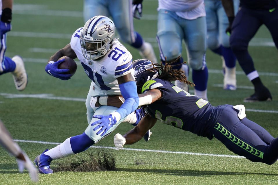 Dallas Cowboys running back Ezekiel Elliott (21) is tackled by Seattle Seahawks cornerback Ryan Neal during the second half of an NFL football game, Sunday, Sept. 27, 2020, in Seattle. (AP Photo/Elaine Thompson)