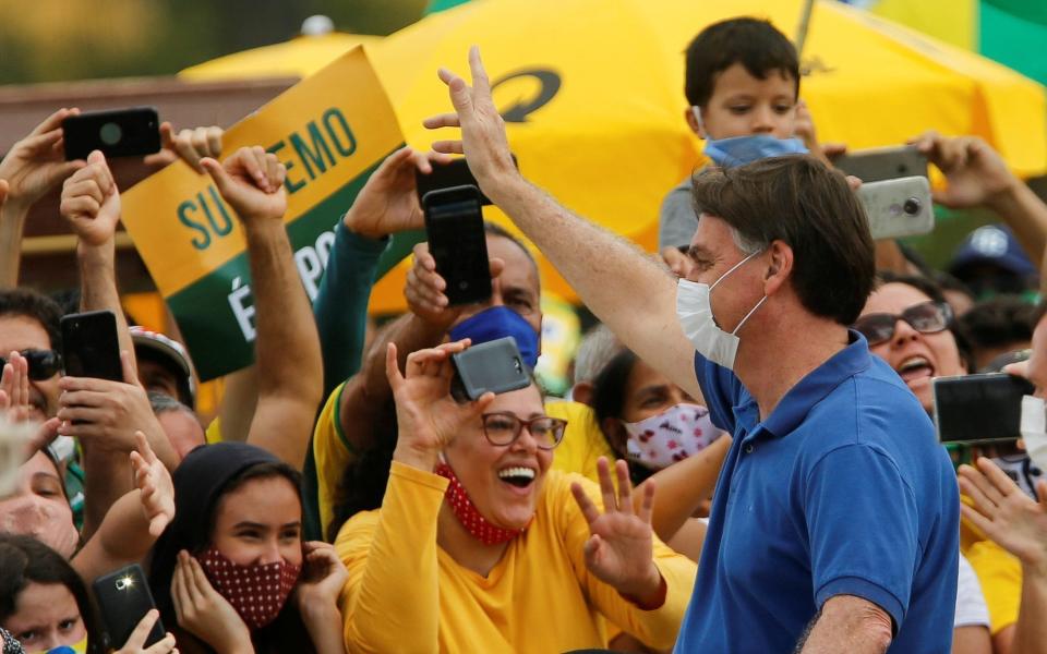 Brazil's President Jair Bolsonaro greets supporters during a protest against social distancing measures  - REUTERS/Adriano Machado