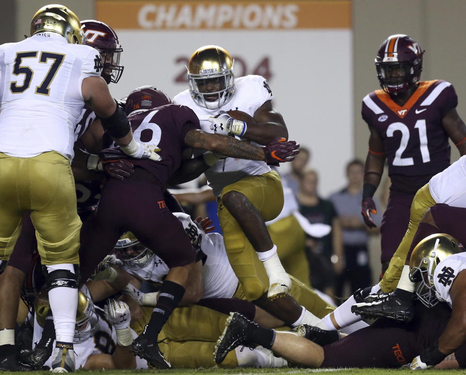 Notre Dame's Dexter Williams (2) fights his way into the end zone for a touchdown against Virginia Tech during the first half of an NCAA college football game Saturday, Oct. 6, 2018, in Blacksburg, Va. (Matt Gentry/The Roanoke Times via AP)